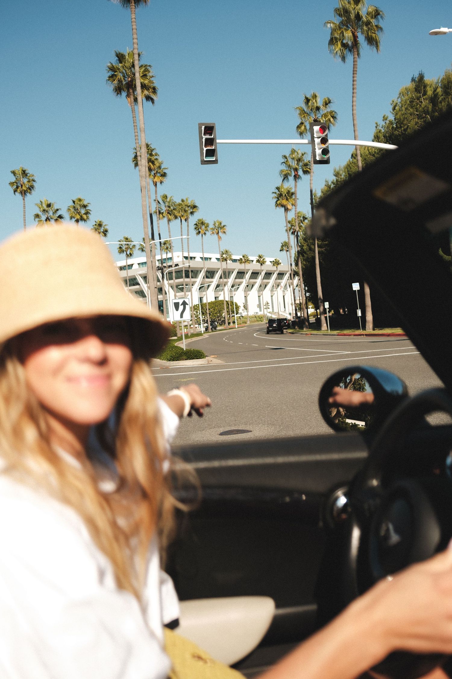 Palm trees and stadium architecture visible in a sunny Los Angeles parking lot.