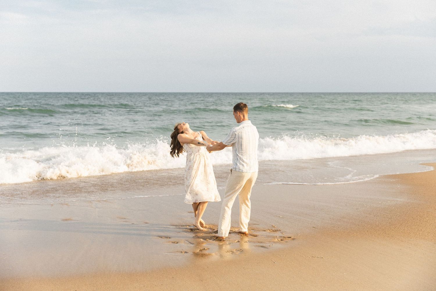 North Carolina Photographer captures couple holding hands, spinning in a circle, laughing during their engagement photos