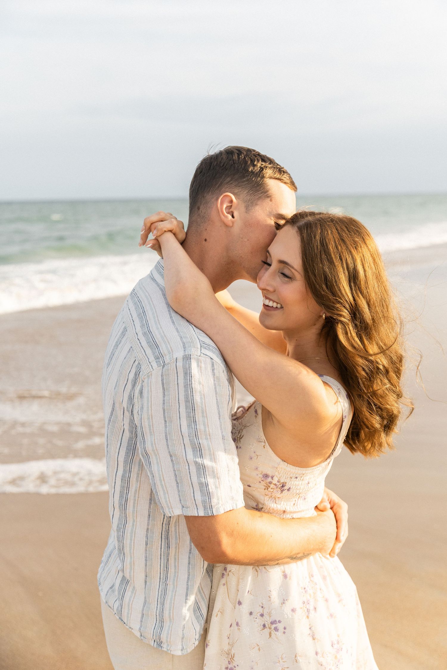 guy kissing girl on the cheek during their golden hour couple portraits