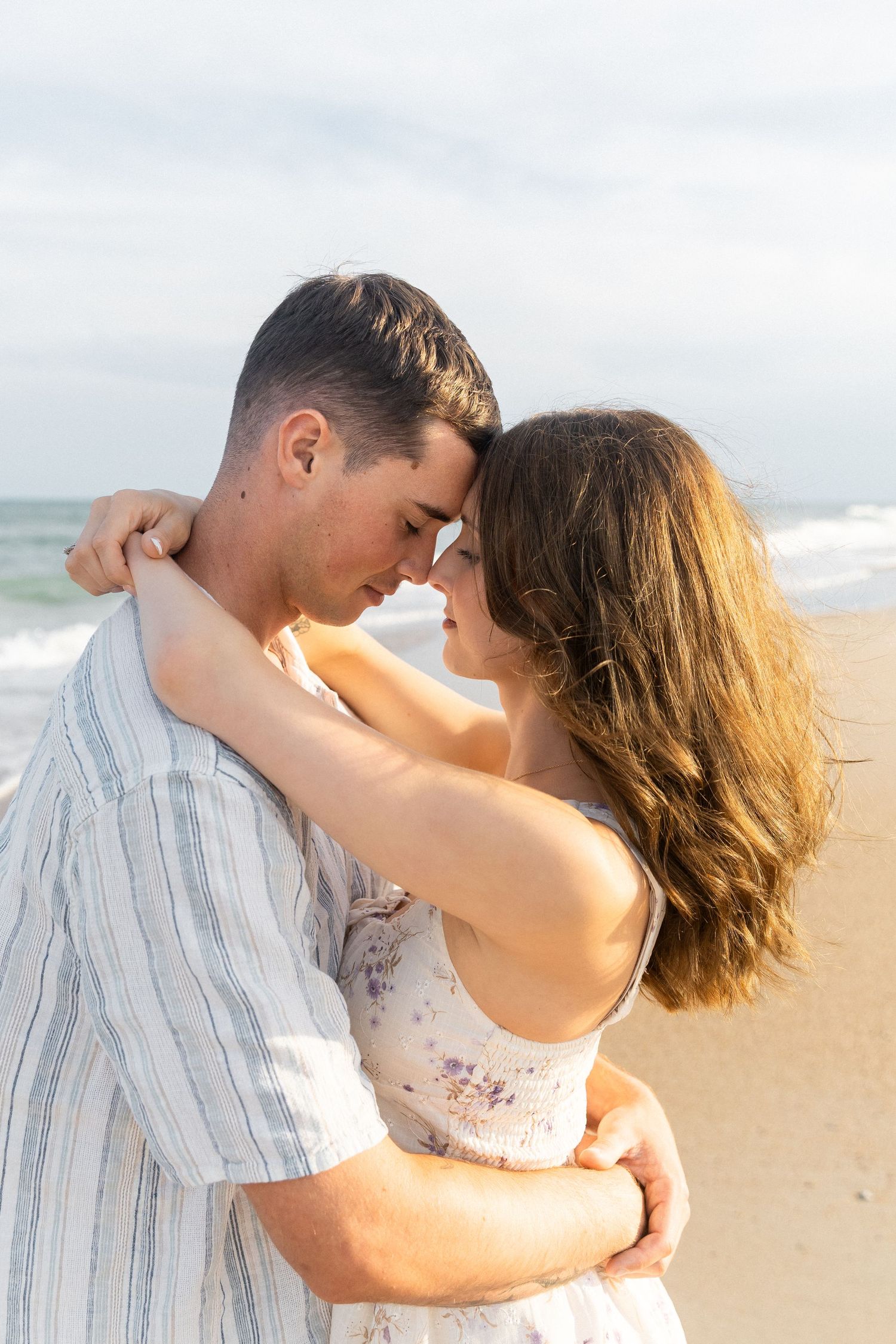 couple embracing in hug in golden lighting on the beach