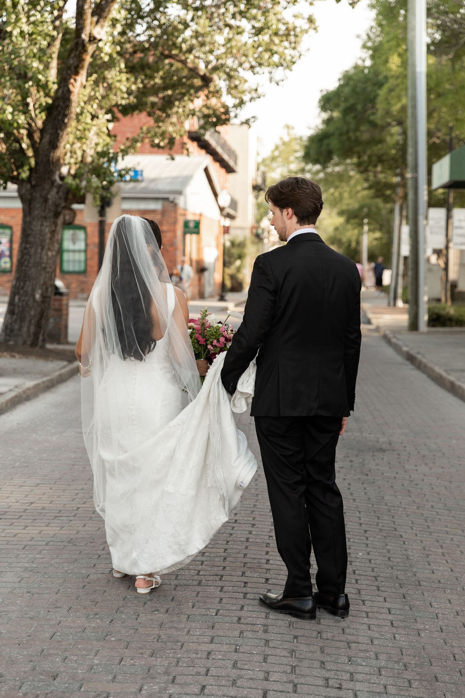 couple walking in the streets of downtown Wilmington during their wedding day
