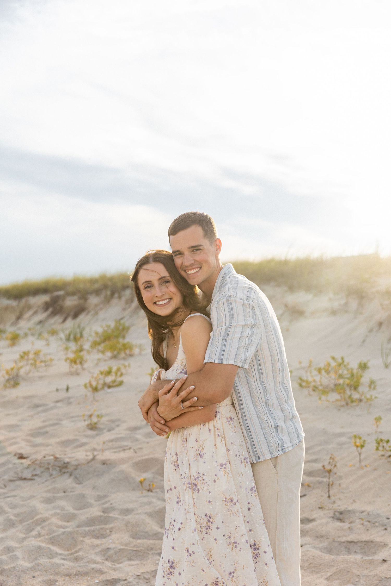 couple smiles at the camera during their engagement photos on topsail beach