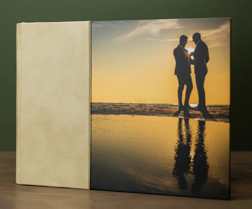 Photo book with a sunset beach silhouette cover showing two people embracing by the ocean waves.