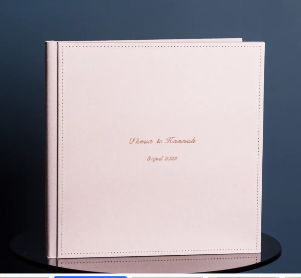 Personalized pink leather wedding photo album embossed with couple names and April 2020 date.