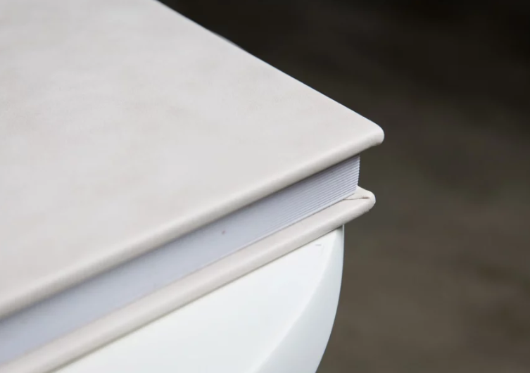 Close-up of a white furniture piece with smooth rounded edges and a clean matte finish surface.