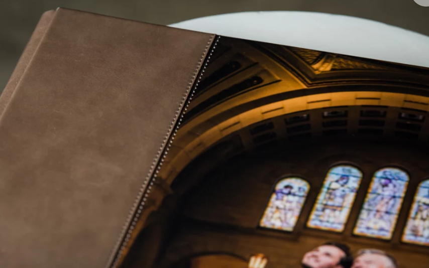 Leather-bound photo album with zipper closure displaying a church interior with stained glass windows.