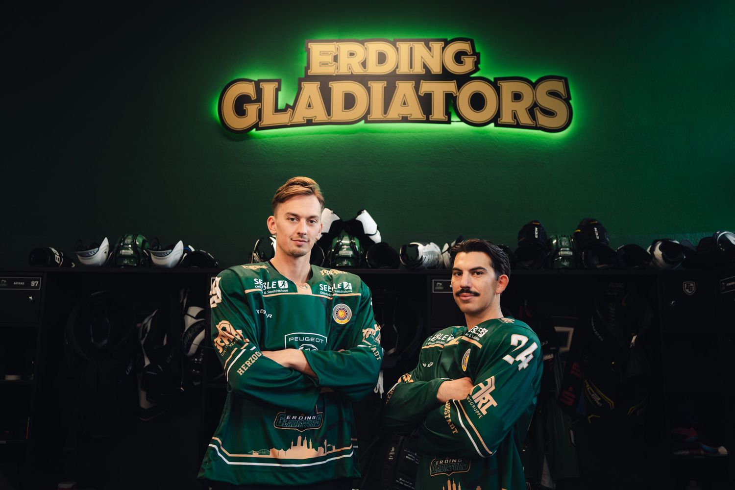 Eishockeyspieler präsentieren Trikots.
