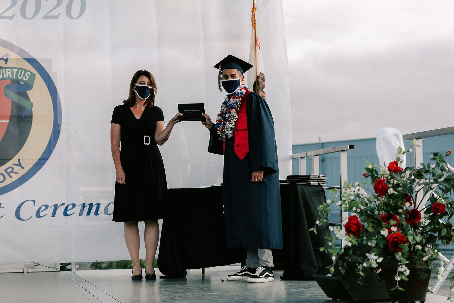 Two masked individuals on stage during Temecula Preparatory School 2020 graduation ceremony.