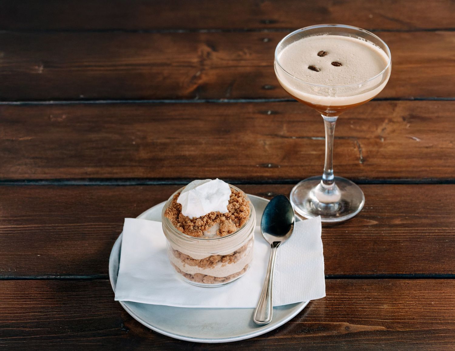 Layered crumble dessert in a mason jar with whipped topping — styled food photo by James Fujita in Kelowna, Okanagan Valley.
