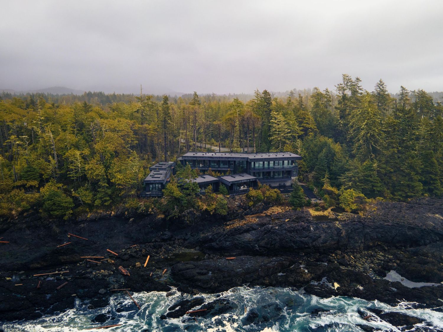 Coastal lodge nestled among evergreens and rocky shoreline — Okanagan & BC hospitality photographer James Fujita.