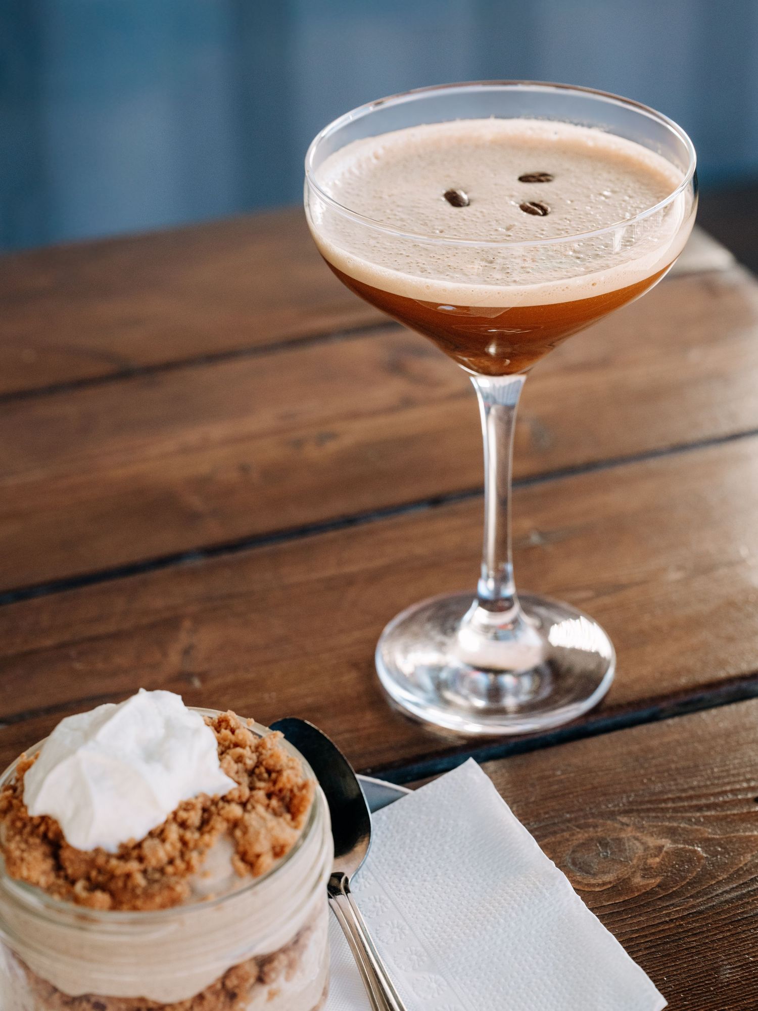 Espresso martini and crumble dessert styled together on a wooden table — luxury food photography by James Fujita, serving Kelowna and the Ok
