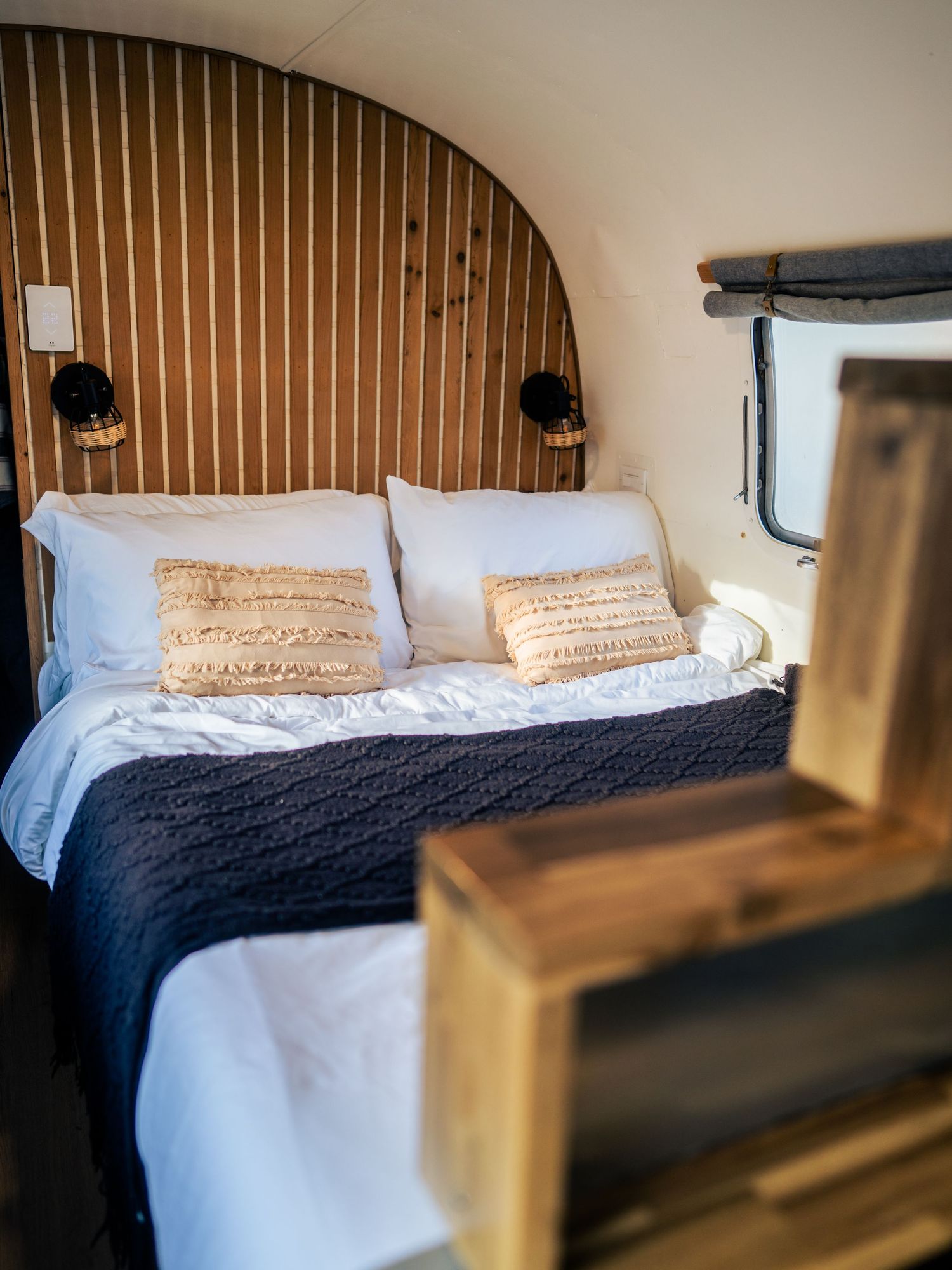 Cozy A-frame bedroom with warm wood tones and natural light — interior and hospitality photography by James Fujita in the Okanagan, British