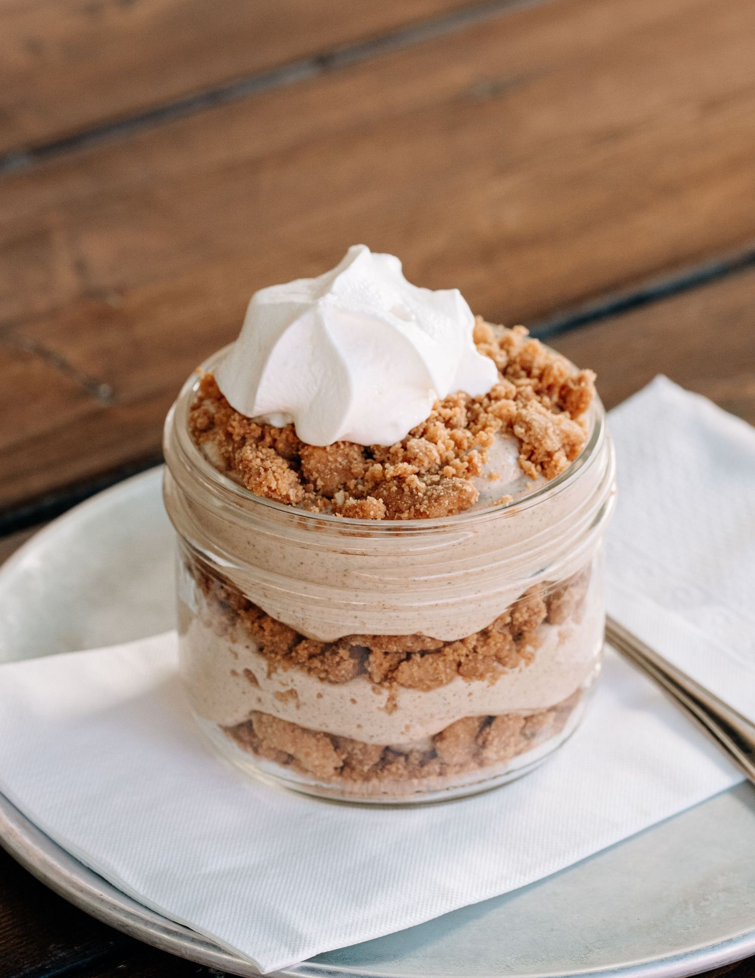 Layered crumble dessert in a mason jar with whipped topping — styled food photo by James Fujita in Kelowna, Okanagan Valley.