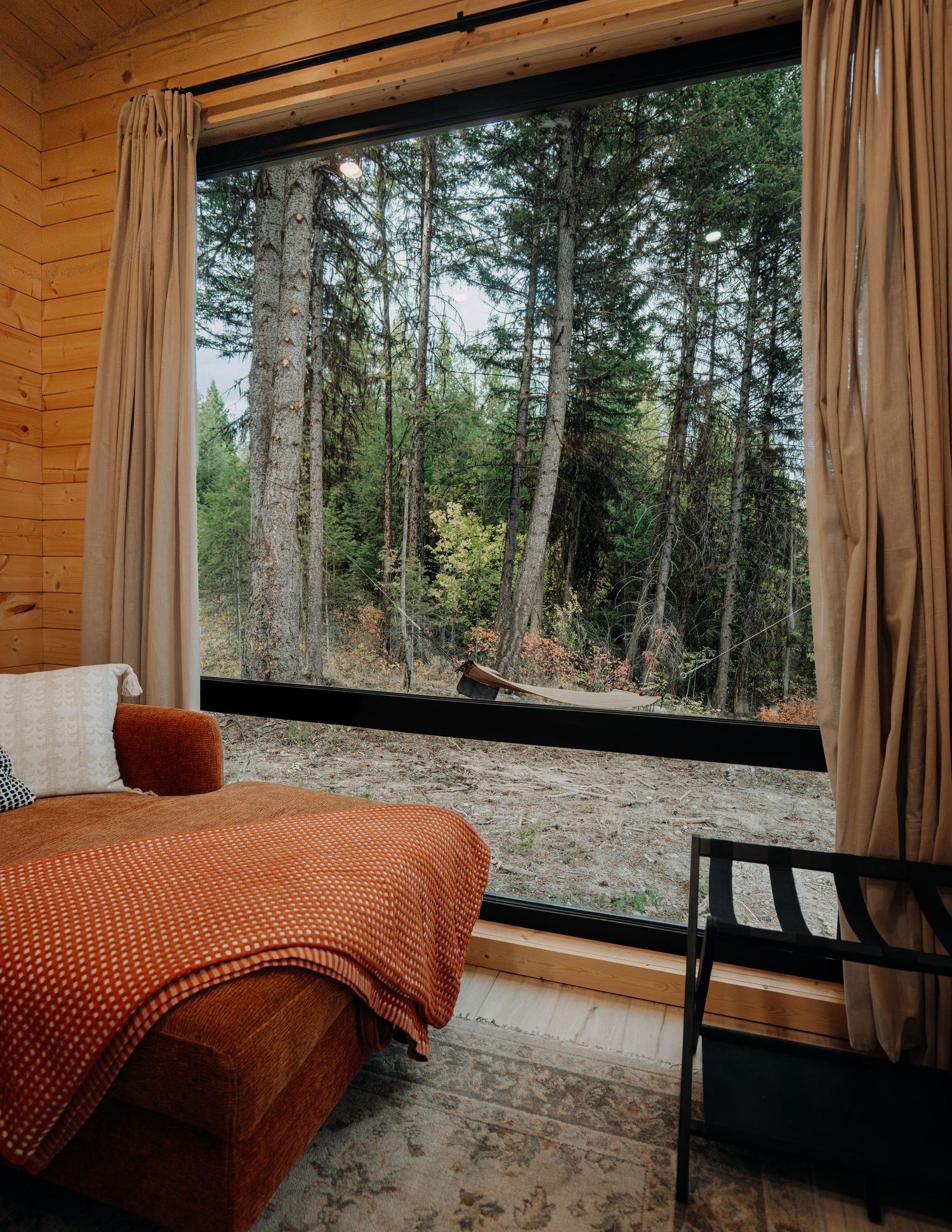 Modern cabin bedroom with panoramic forest views — interior and resort photography by James Fujita in British Columbia.