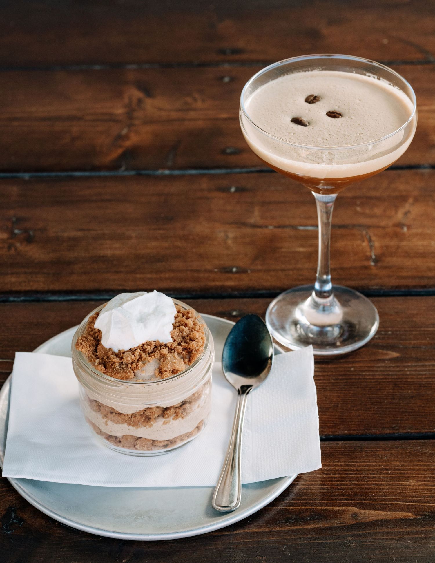 Espresso martini and dessert photographed on a rustic wooden table — captured by Okanagan food photographer James Fujita in Kelowna, BC. Pe