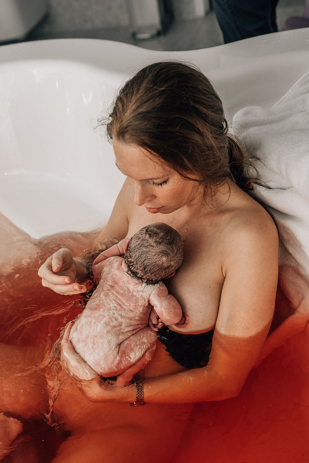mother giving birth in a bathtub captured by dubai birth photographer