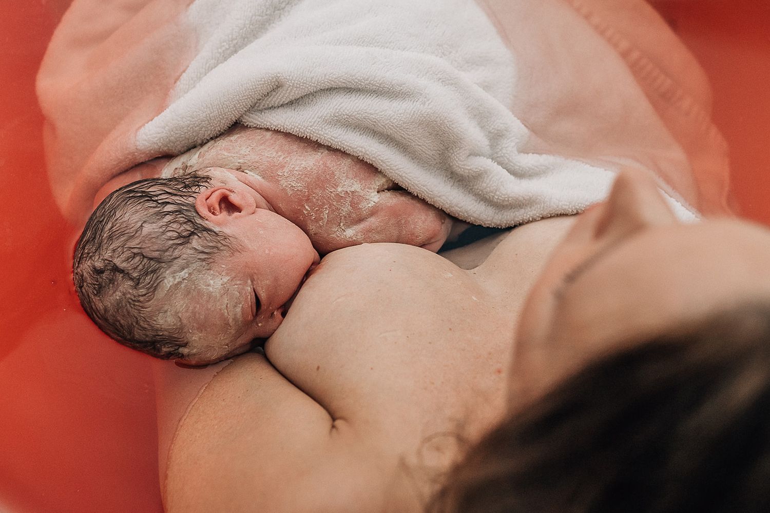 mom nursing her baby in a bathtub right after birth in al zahra hospital in dubai captured by dubai birth photographer