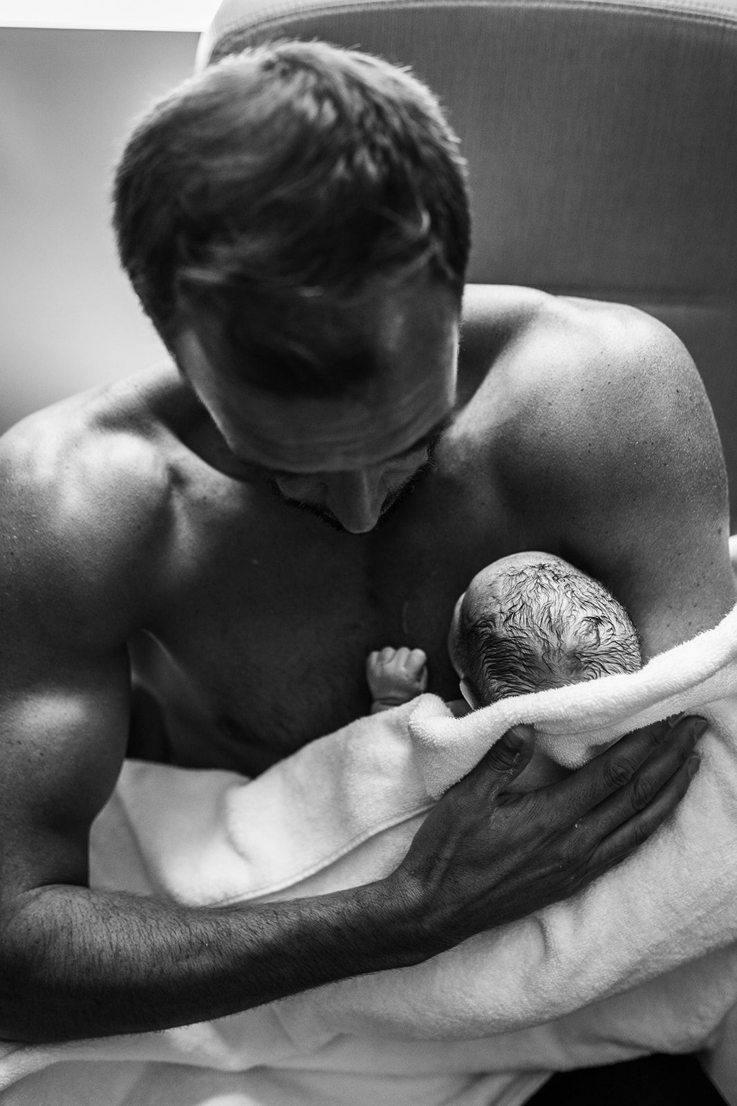 father embracing his newborn baby girl during a birth shoot in dubai