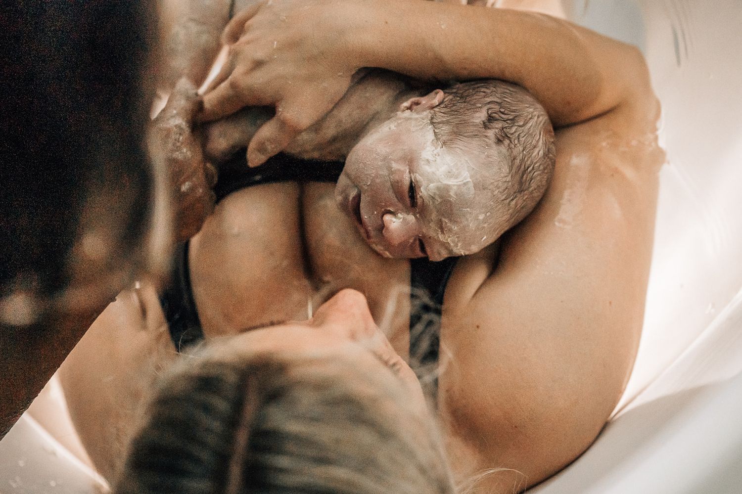 newborn on mother's check looking at mom during a birth photoshoot in dubai
