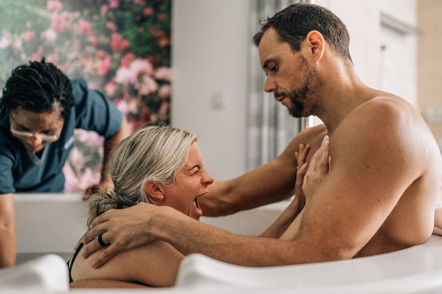 dad supporting mom during water birth