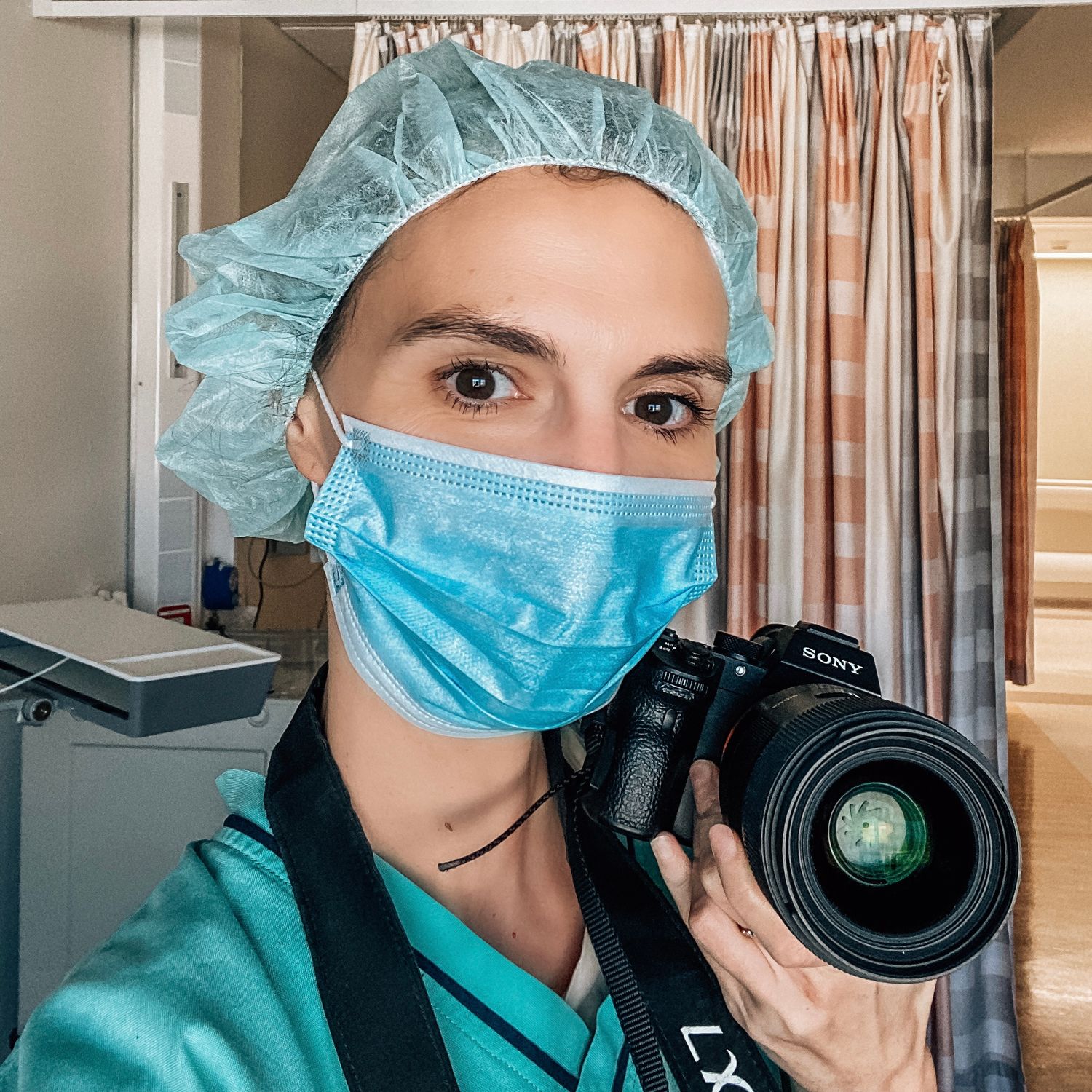 dubai birth photographer wearing scrubs and face mask during a cesarean birth in dubai