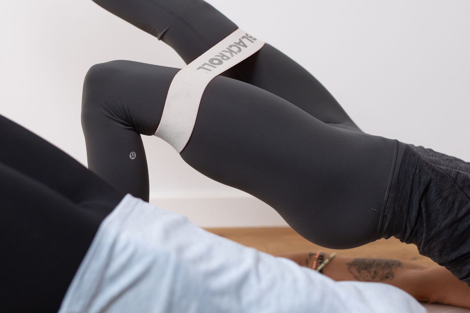 Close-up of black compression leggings with white brand label detail.