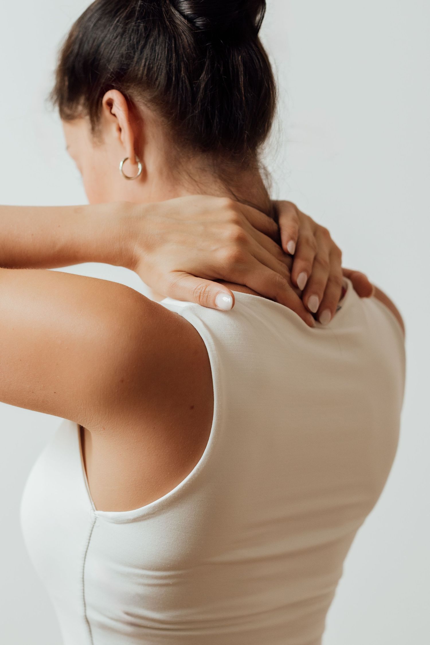 Person massaging their neck and shoulder area to relieve tension.