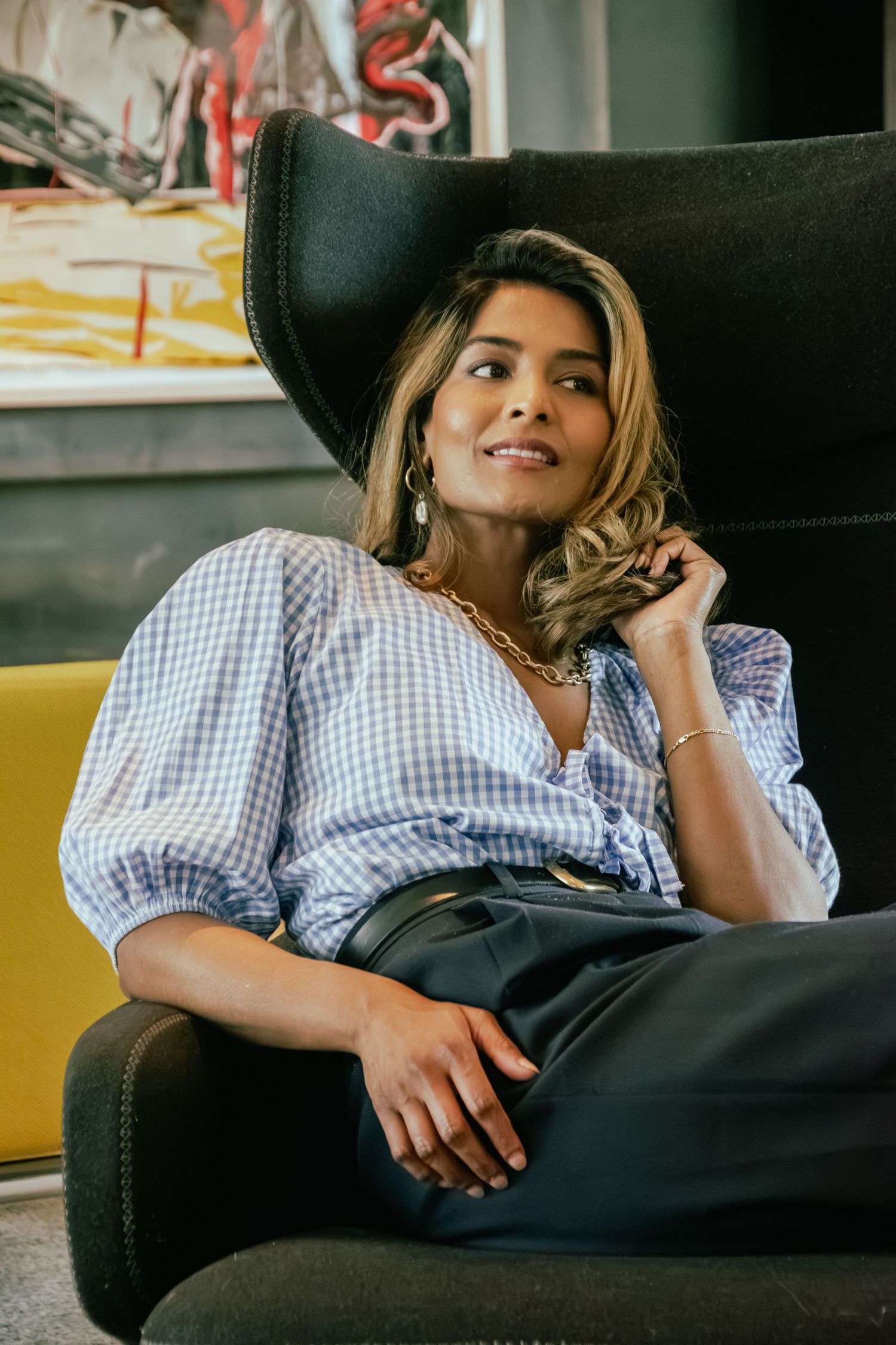 Relaxed personal branding portrait of a female entrepreneur seated in a modern interior in Rotterdam.