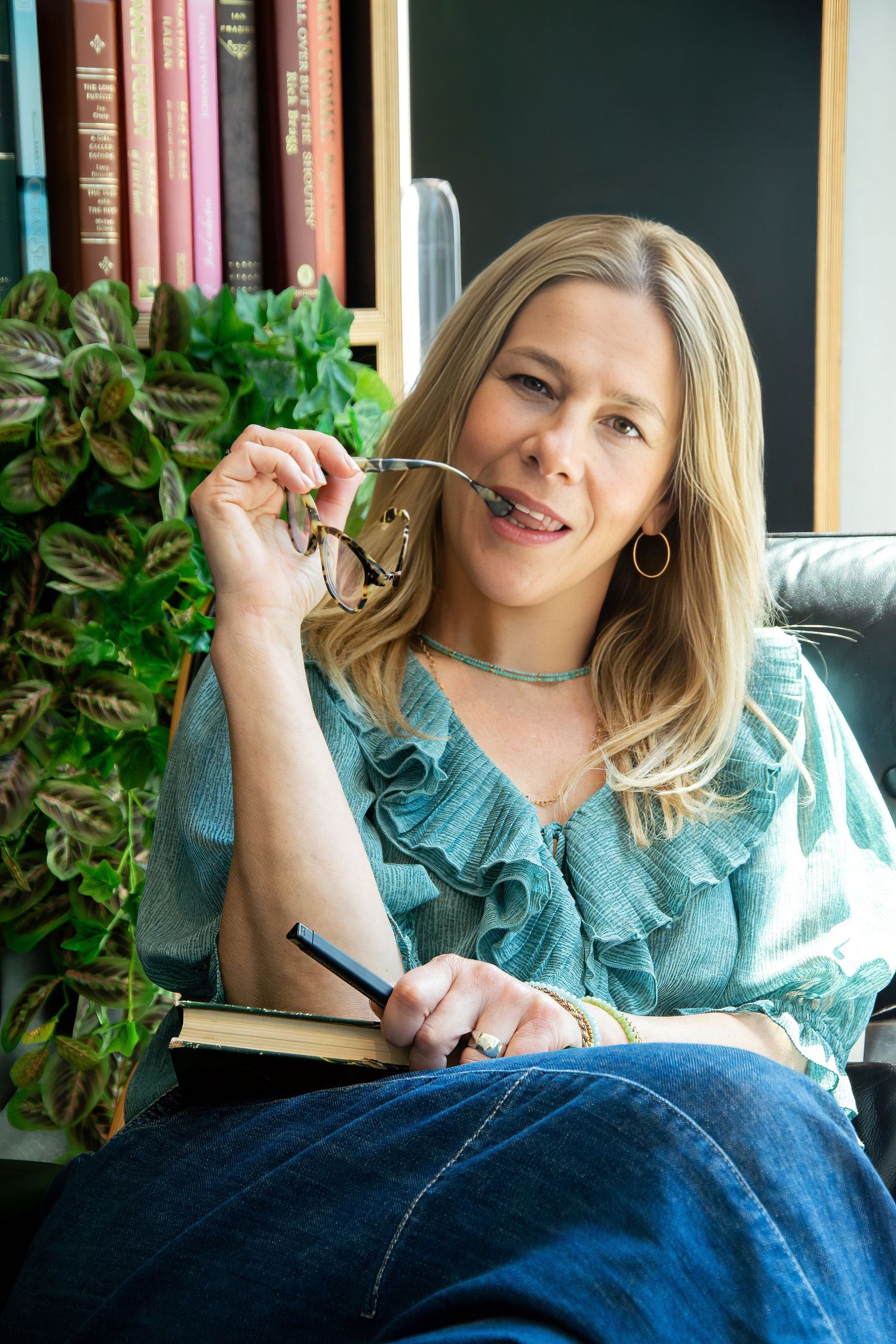 Relaxed personal branding portrait of a female entrepreneur with notebook in a creative workspace in Rotterdam.