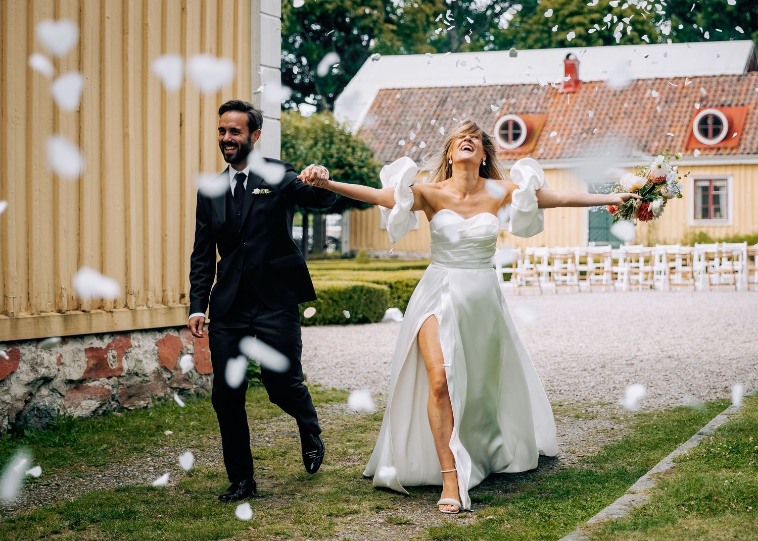 Playful wedding celebration moments captured on wooden deck with confetti.