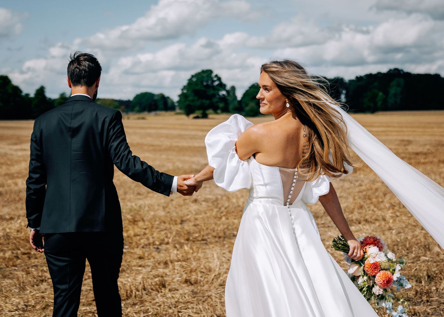 Romantic wedding couple shares intimate moments in a golden wheat field with soft lighting and natural scenery.