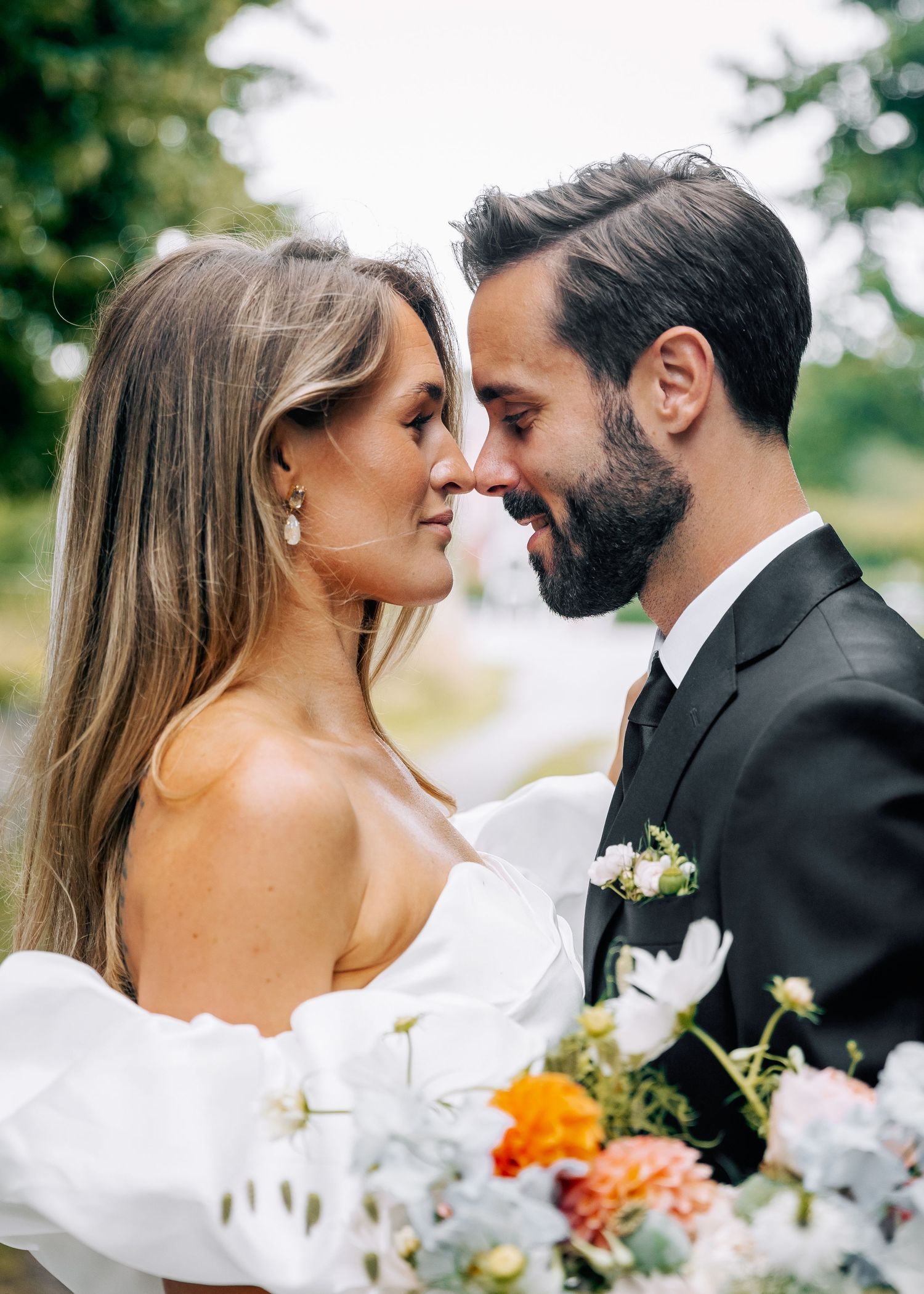 Intimate close-up of wedding couple with floral bouquet.