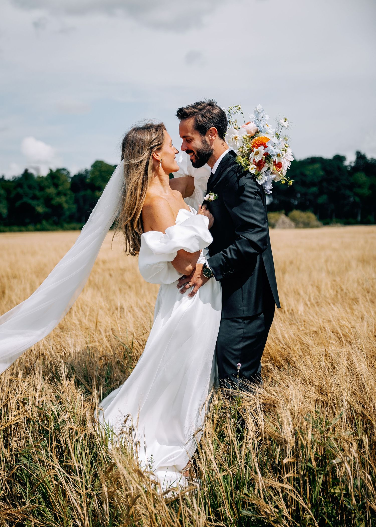 Wedding couple sharing intimate moment in golden wheat field.