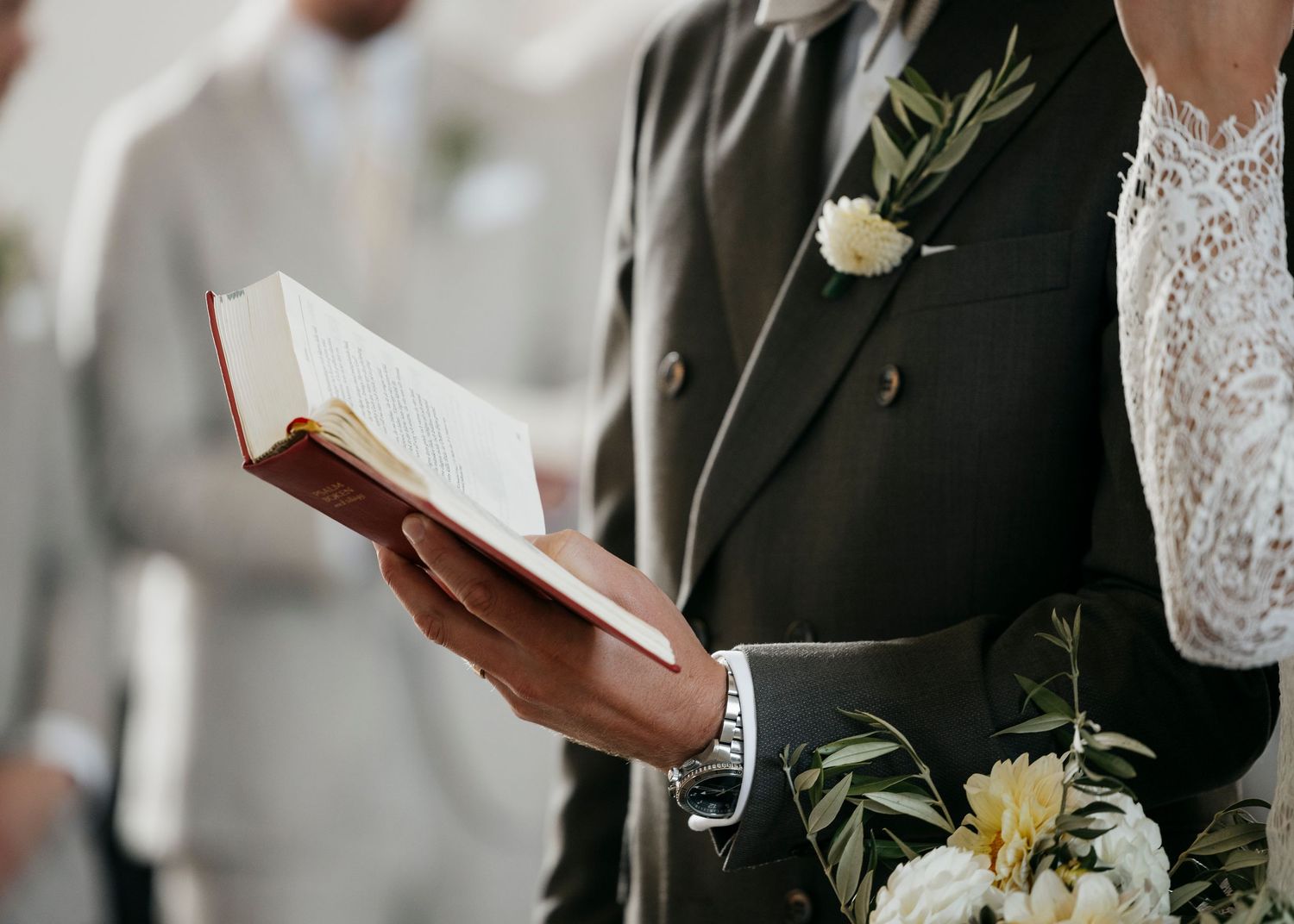 Close-up of wedding ceremony details showing bouquet and formal attire.