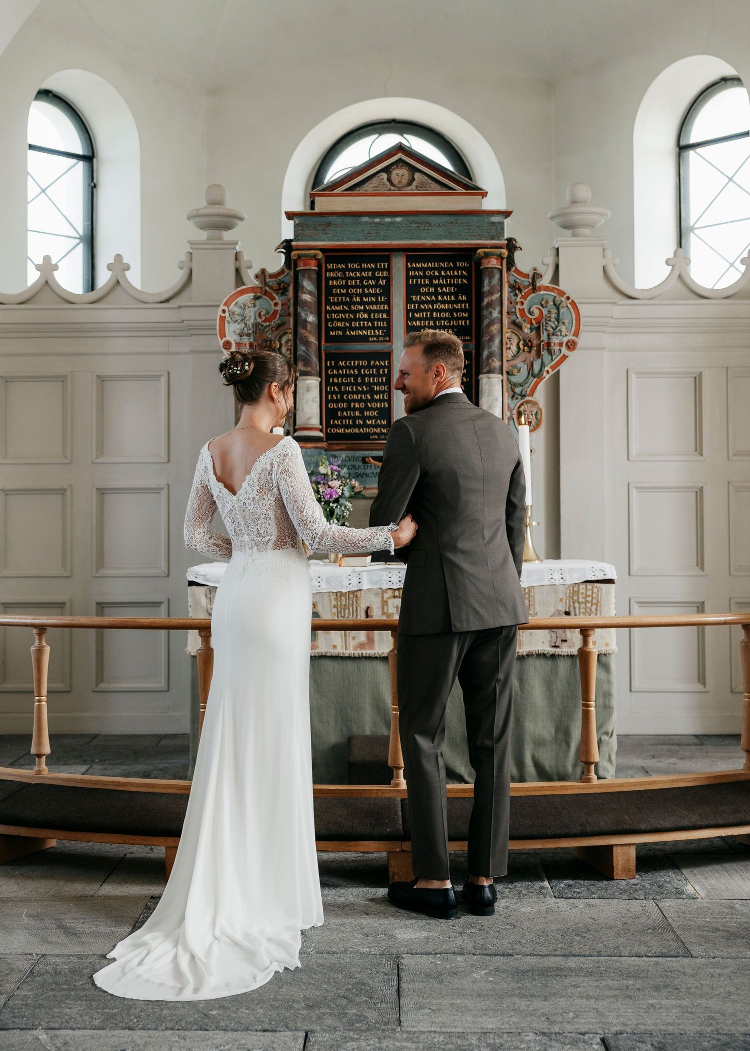 Wedding ceremony moments captured inside historic church with white paneled walls.
