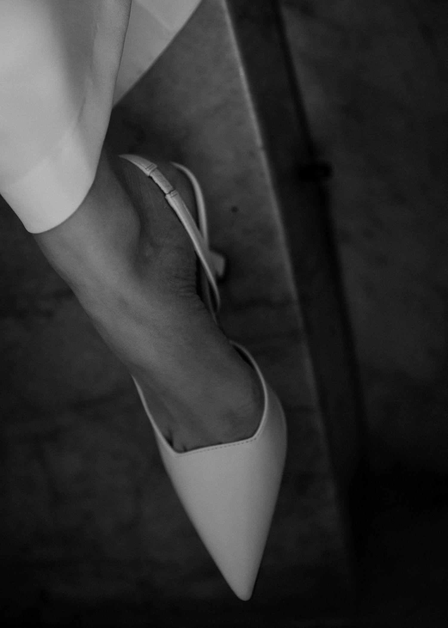 Elegant white heels against a dark background in a wedding setting.