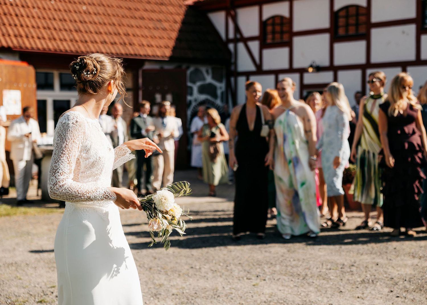 Wedding celebration outside a traditional German-style timber frame building with guests gathered.