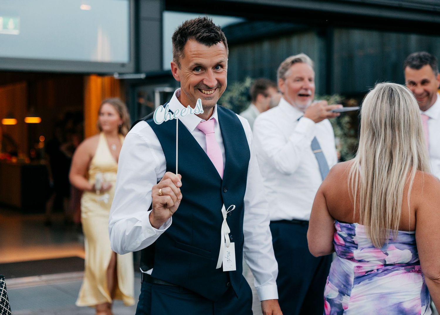 Wedding reception guests dancing and celebrating on outdoor patio.