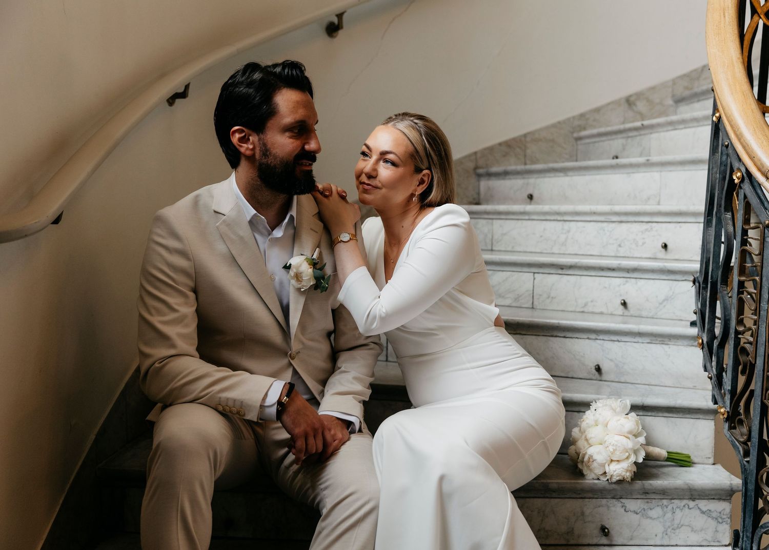 A series of romantic poses between a couple on a classic marble staircase.