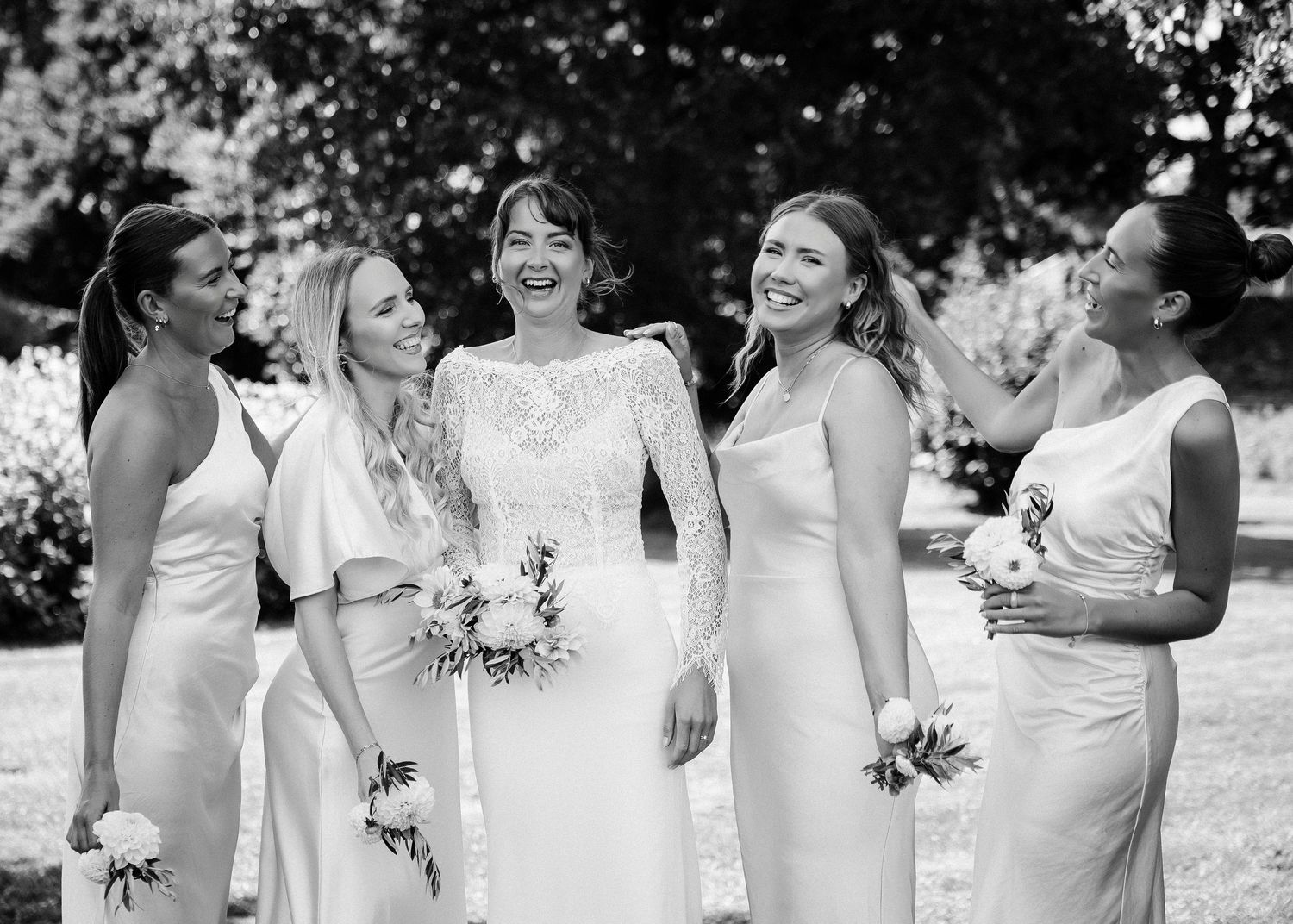 Wedding party poses in black and white photo wearing light colored formal attire.