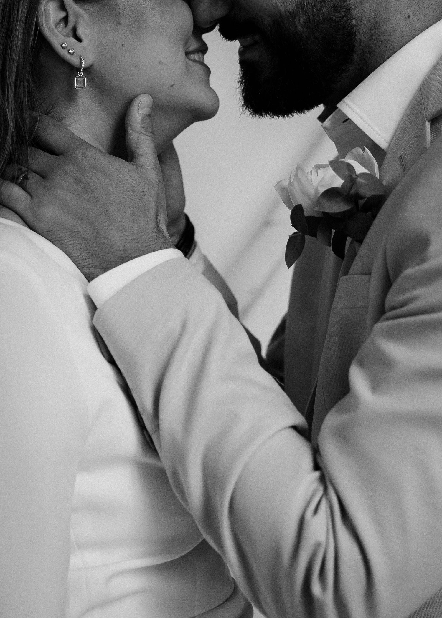 Black and white close-up shots of a couple sharing an intimate moment in formal attire.