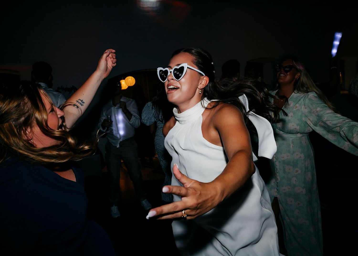 People dancing and celebrating at a dimly lit party or celebration.
