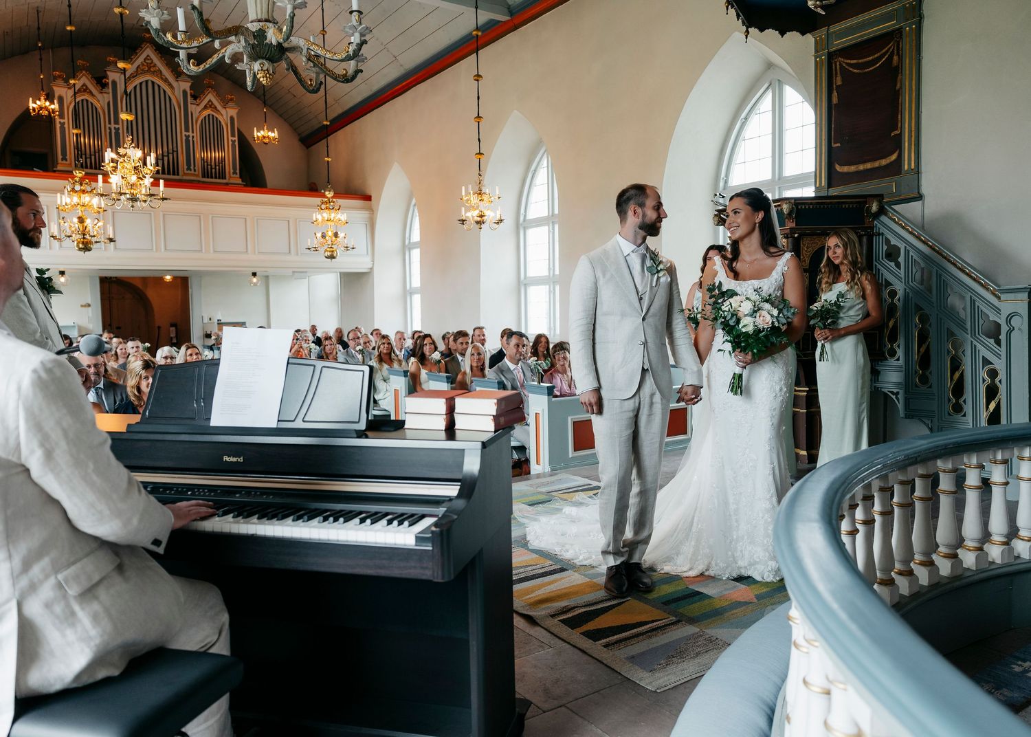 Wedding ceremony moments in church featuring piano and elegant interior details.