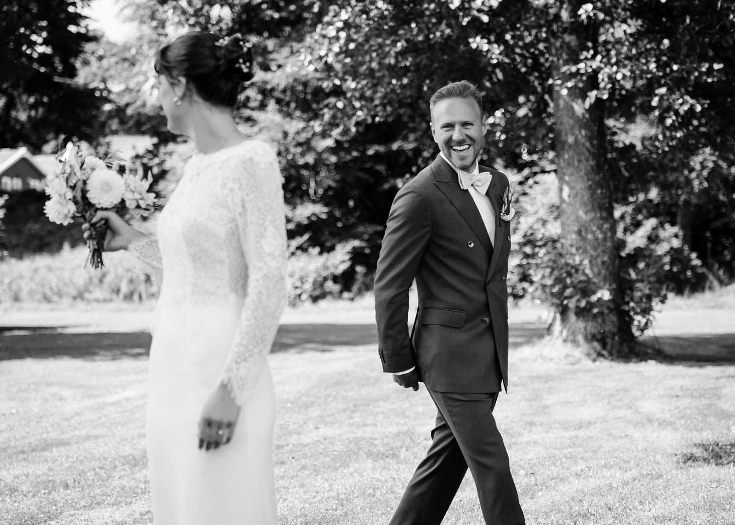A romantic wedding couple poses together in an outdoor garden setting with natural lighting.