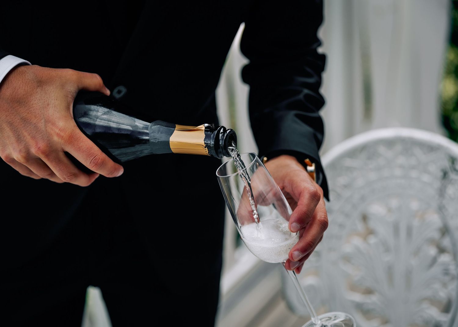 Close-up shots of champagne being poured into elegant wedding glasses.
