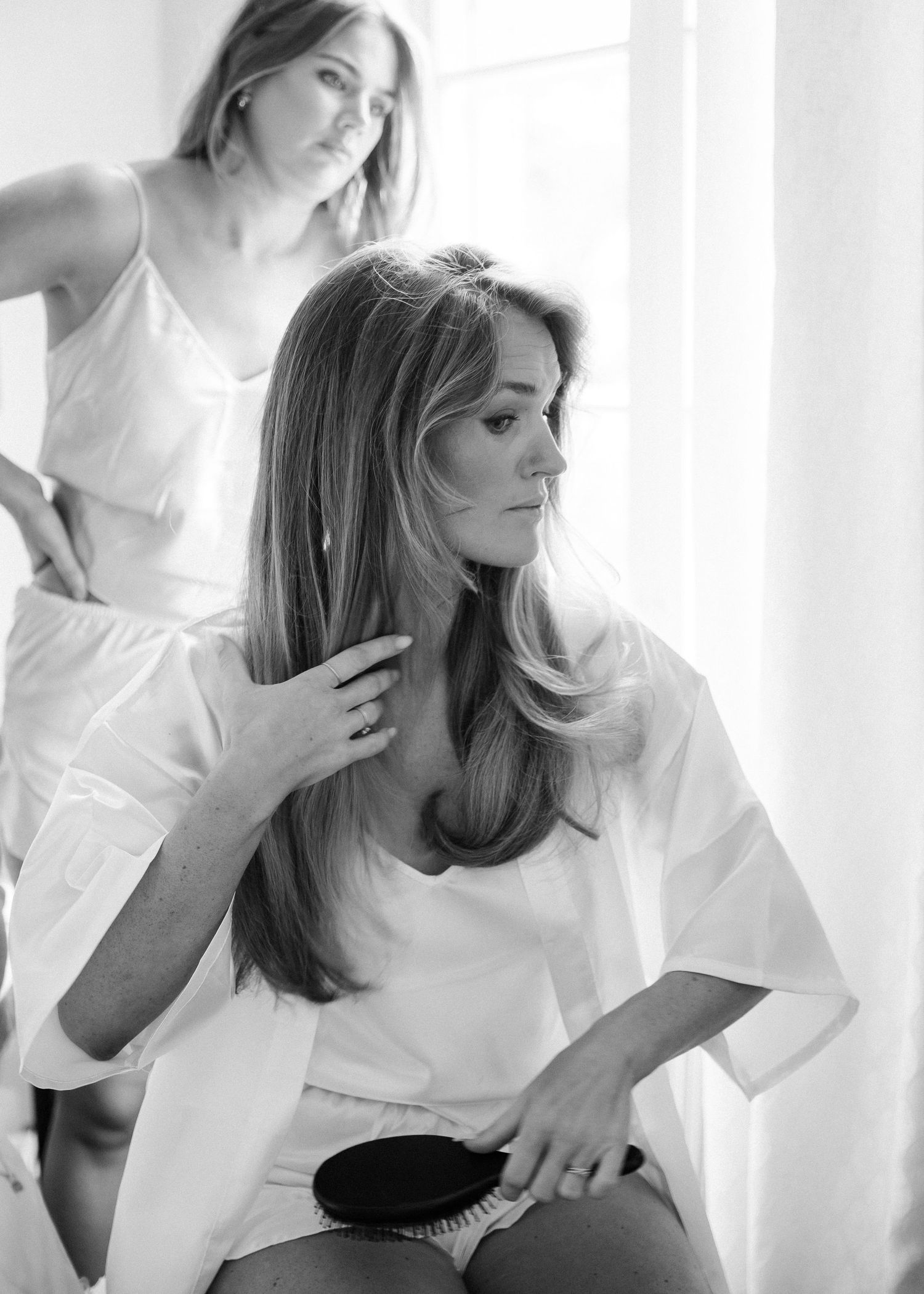 Black and white image of styling session with hair brush.