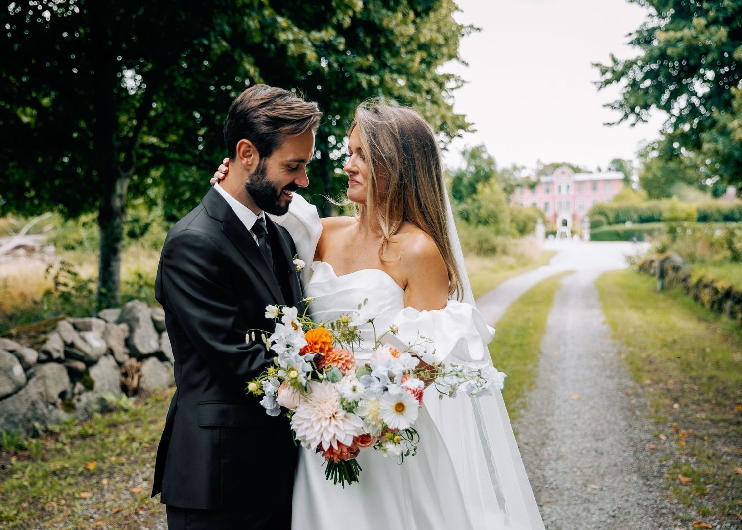 Wedding couple portraits on a gravel path surrounded by lush greenery.