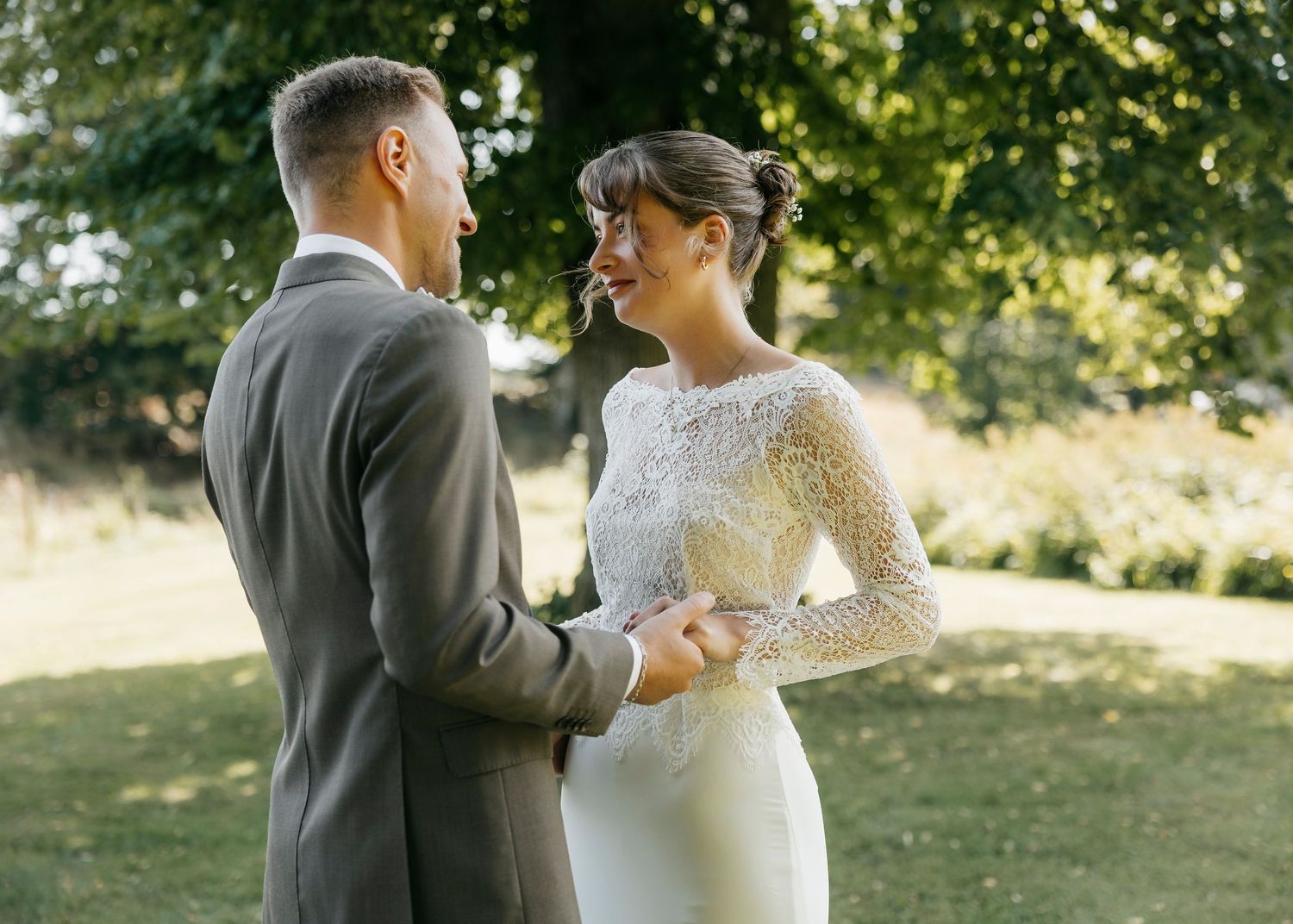 A romantic outdoor wedding scene with the couple sharing a tender moment against nature.