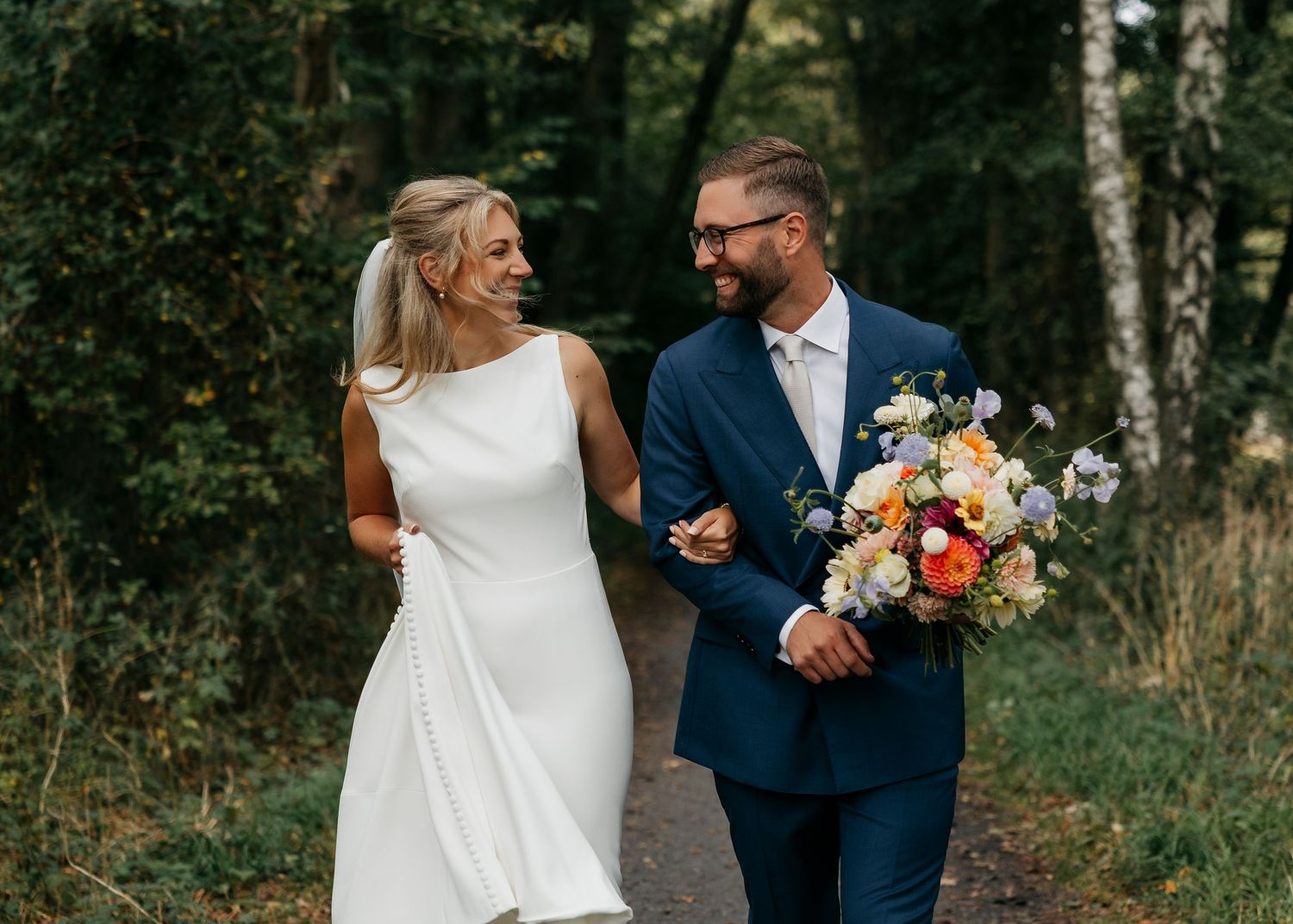 A couple shares a joyful moment together during an outdoor photo session in a wooded setting.