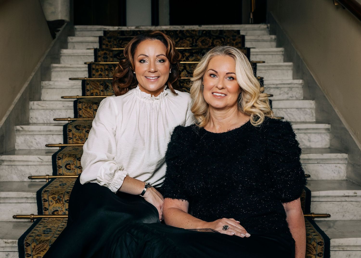 Professional portrait photography session in an elegant indoor setting with classic staircase backdrop.